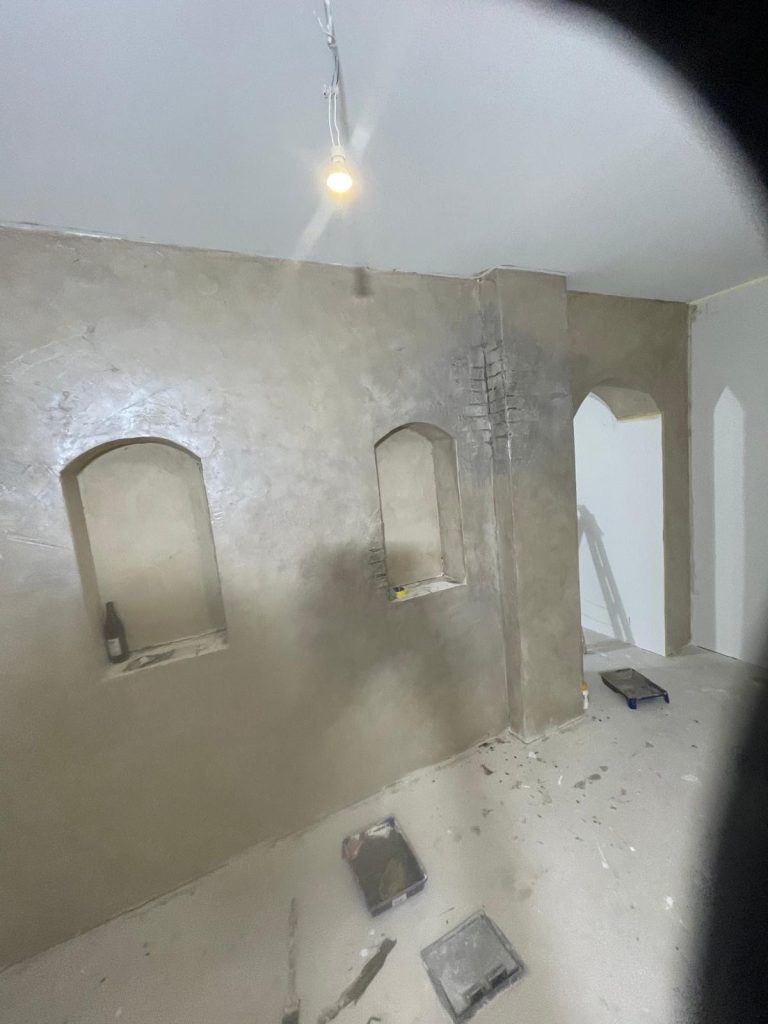 Nachherbild einer Altbausanierung mit restauriertem Torbogen und Schlossoptik-Design im Raum